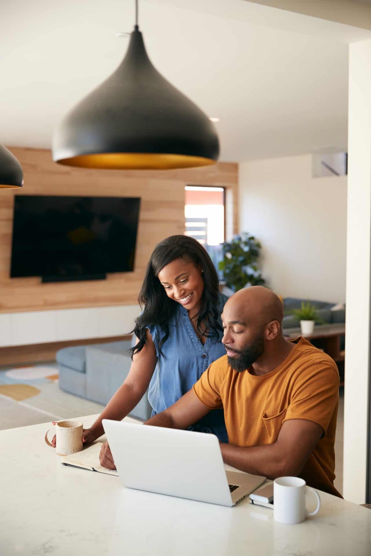 African American couple using laptop to check finances at home